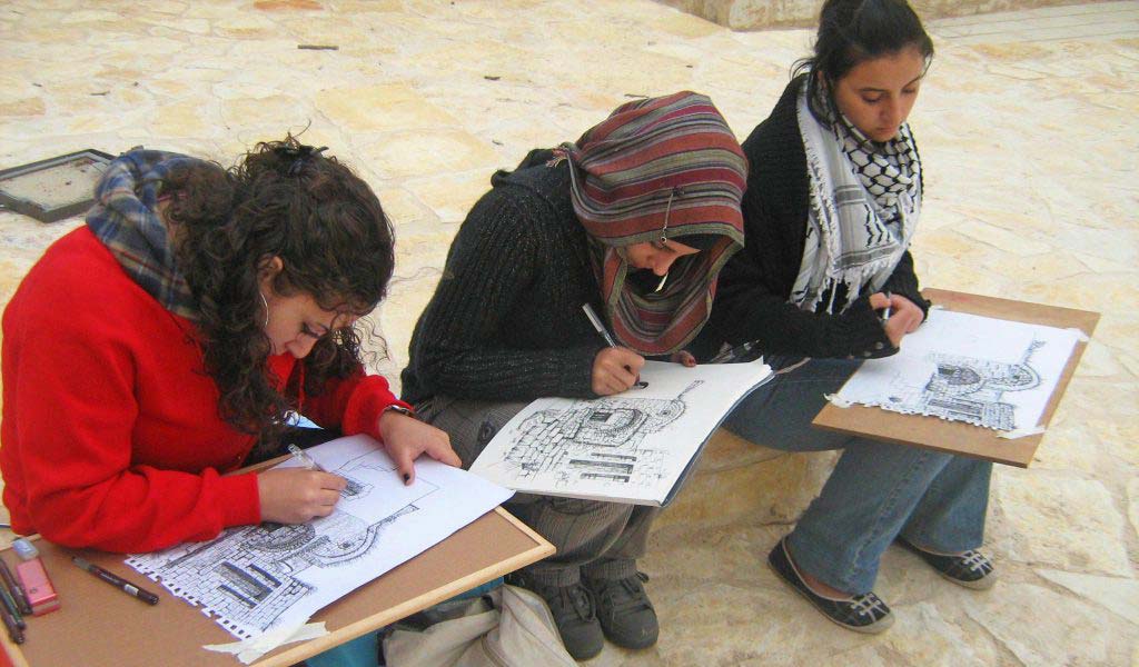 University students sketching buildings for a Riwaq competition. Organized by Riwaq, the Tom Kay Award supports Palestinian engineering students with the aim of encouraging them to spend less time in front of computer screens, and to carry their sketchbooks and pencils to explore, appreciate, draw, and document Palestinian architectural heritage. Image Credit: Riwaq Photo Archive